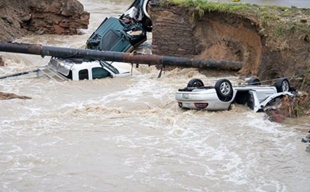 Cars lie in floodwaters after heavy rain undercut a road in Boulder, Colorado, in 2013.