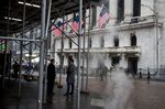Pedestrians pass in front of the New York Stock Exchange (NYSE) in New York, U.S., on Wednesday, Feb. 26, 2020. U.S. equities swung between gains and losses as investors digested fresh evidence of the widening coronavirus outbreak.