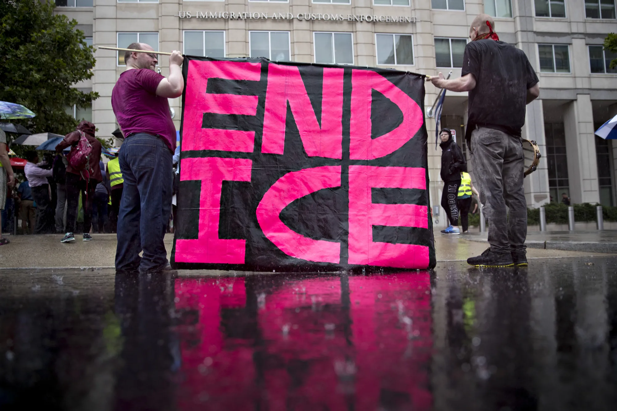 Demonstrators hold a sign that reads "End ICE" during a protest against detaining and separating immigrant families outside of the Immigration and Customs Enforcement headquarters in Washington on June 27, 2018.