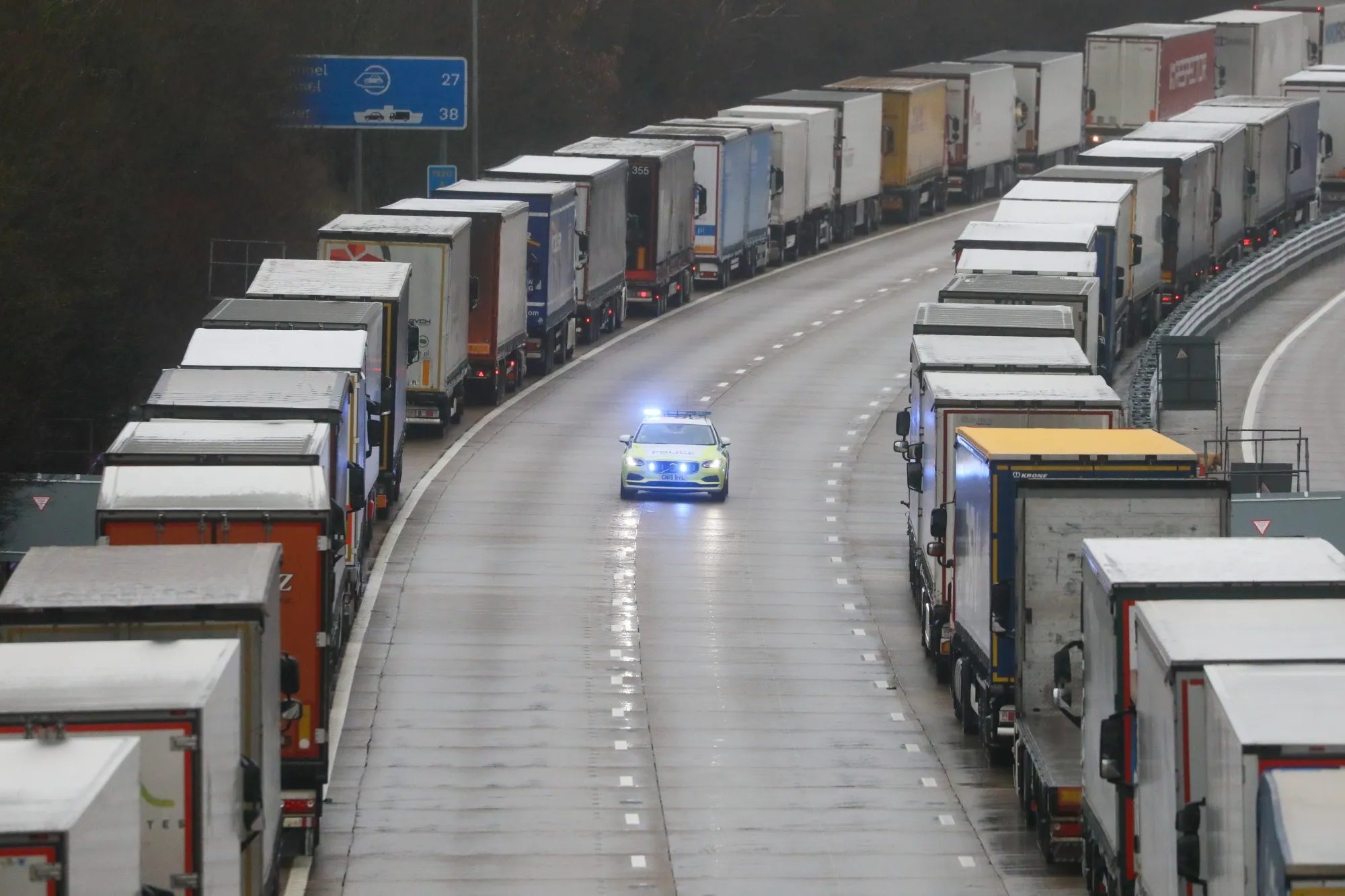 Police pass parked trucks bound for the Port of Dover on the M20 motorway near Ashford, U.K., on Dec. 21.