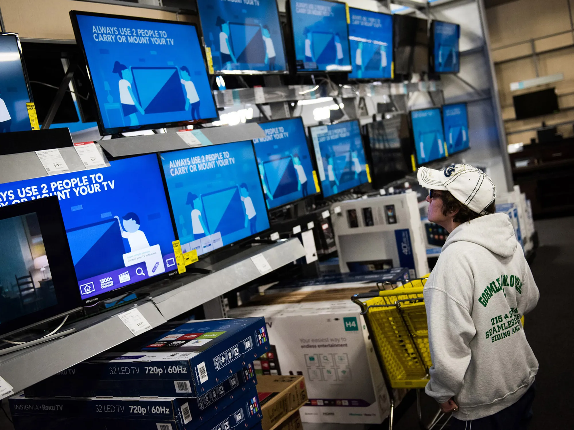 A shopper looks at televisions displayed for sale.