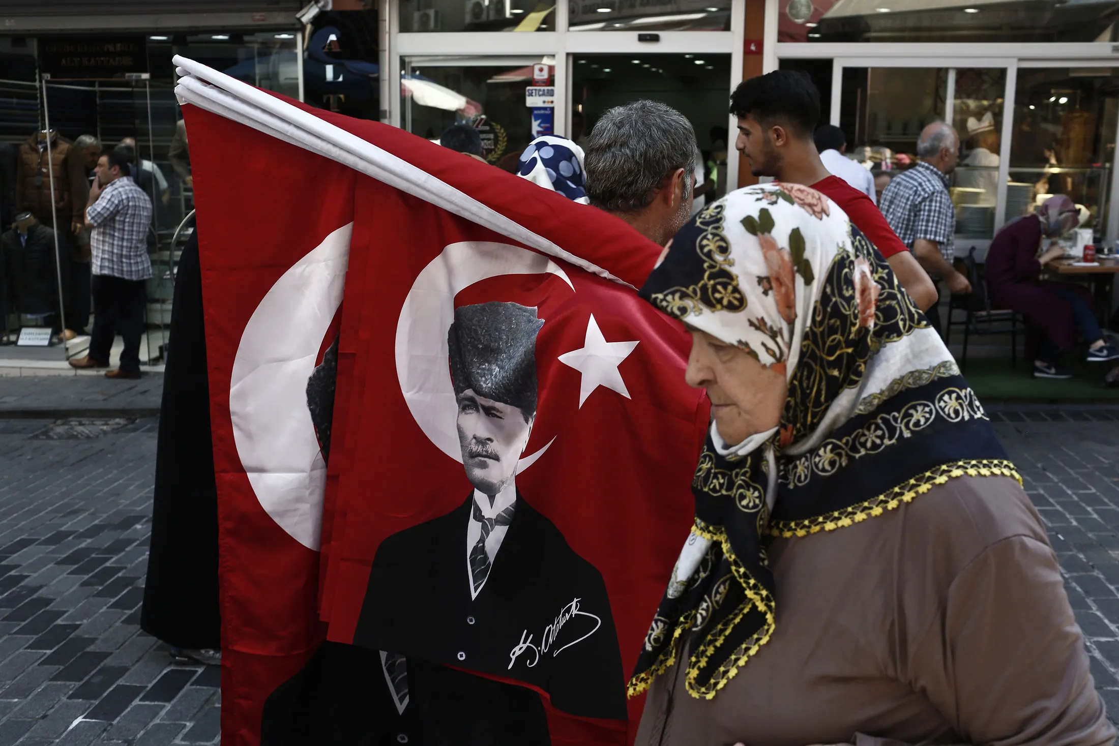 A woman passes a street vendor in Istanbul.
