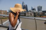A pedestrian shields herself from the sun in London, June 17