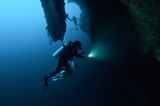 Scuba divers explore the stalactites inside the Great Blue Hole, a giant marine sinkhole, Lighthouse Reef Atoll, Belize