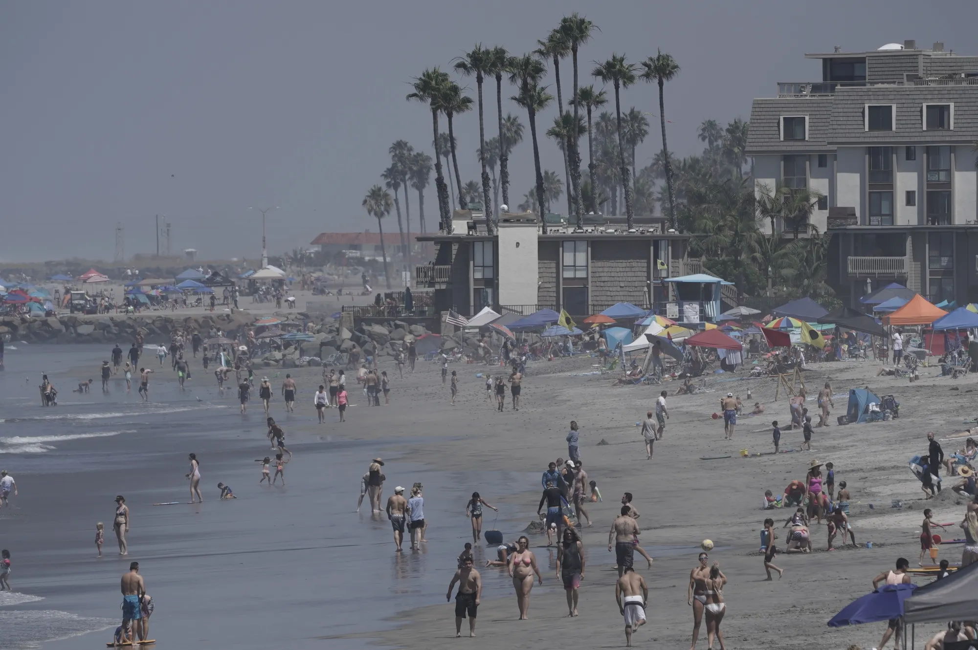People gather on the beach in Oceanside, California.