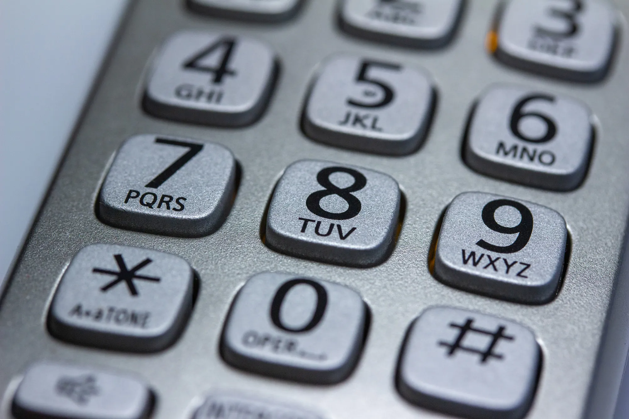 Close abstract view of a silver cordless household telephone