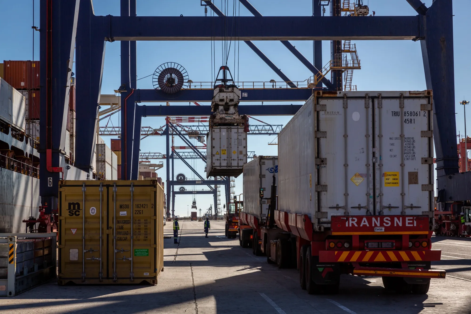 Trucks line up next to a container ship docked at the Port of Cape Town
.