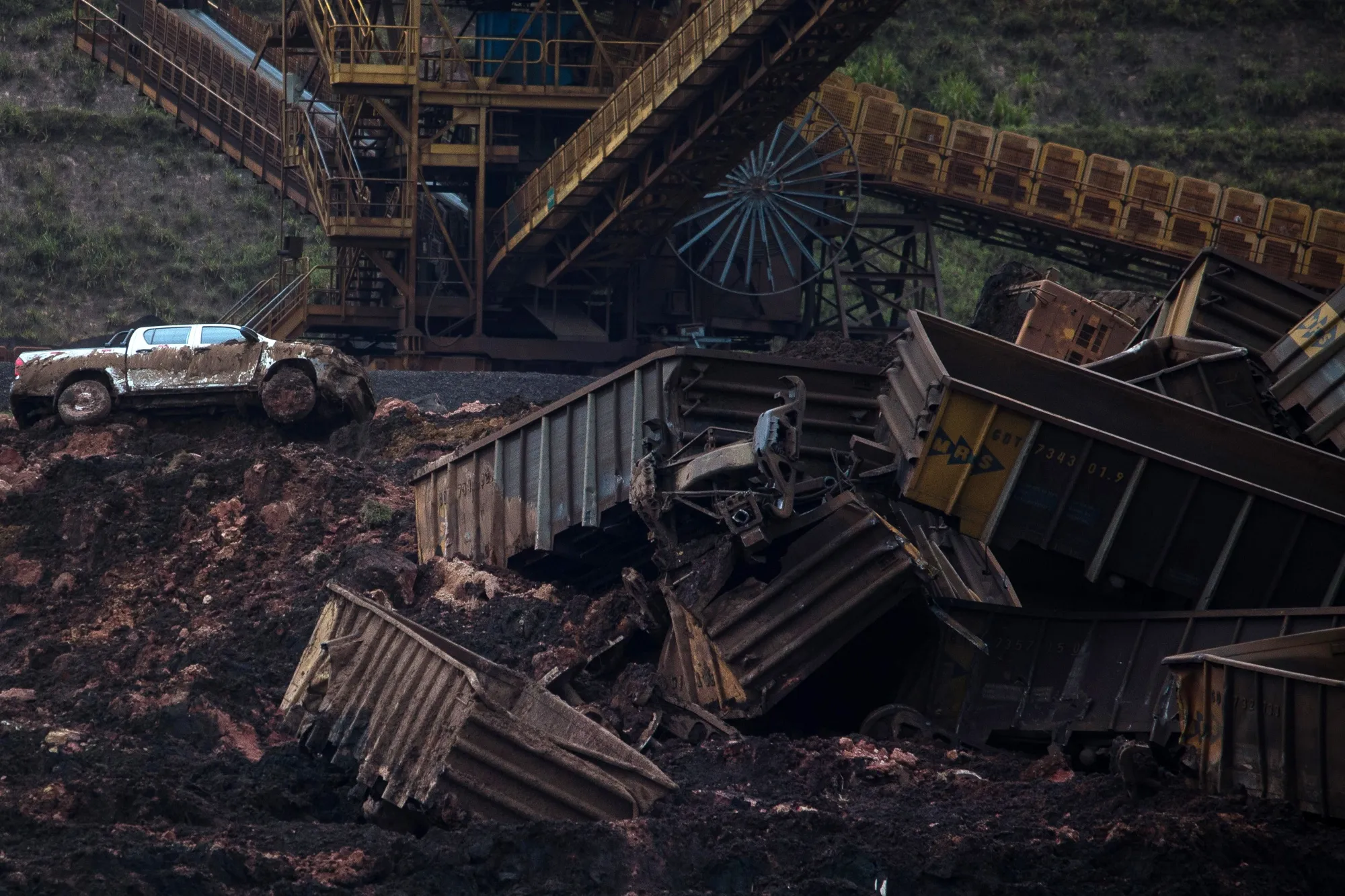 A pickup truck sits among shattered debris after a dam breach.