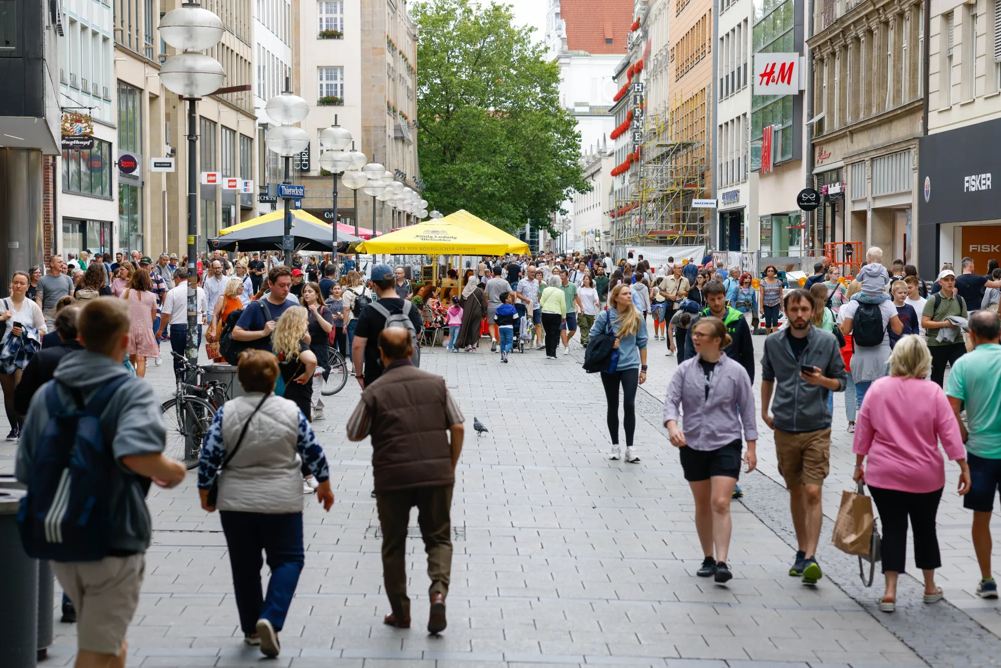 Shoppers walk along a shopping street in downtown Munich, Germany.