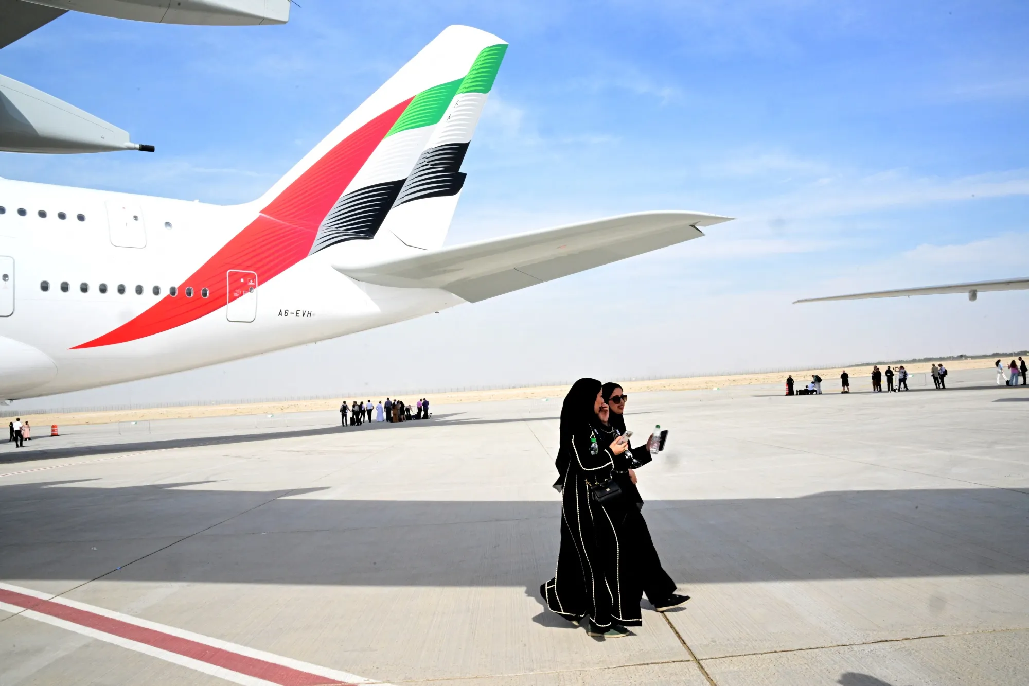 Visitors walk near an Emirates Airbus aircraft at Al-Maktoum International Airport during the Dubai Airshow 2025 in Dubai on Nov. 17.&nbsp;