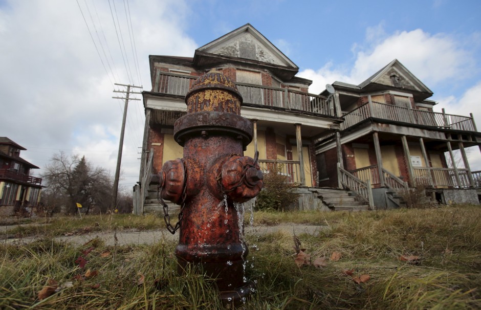 Water leaks from a fire hydrant in front of two boarded-up, vacant houses in Detroit, Michigan.