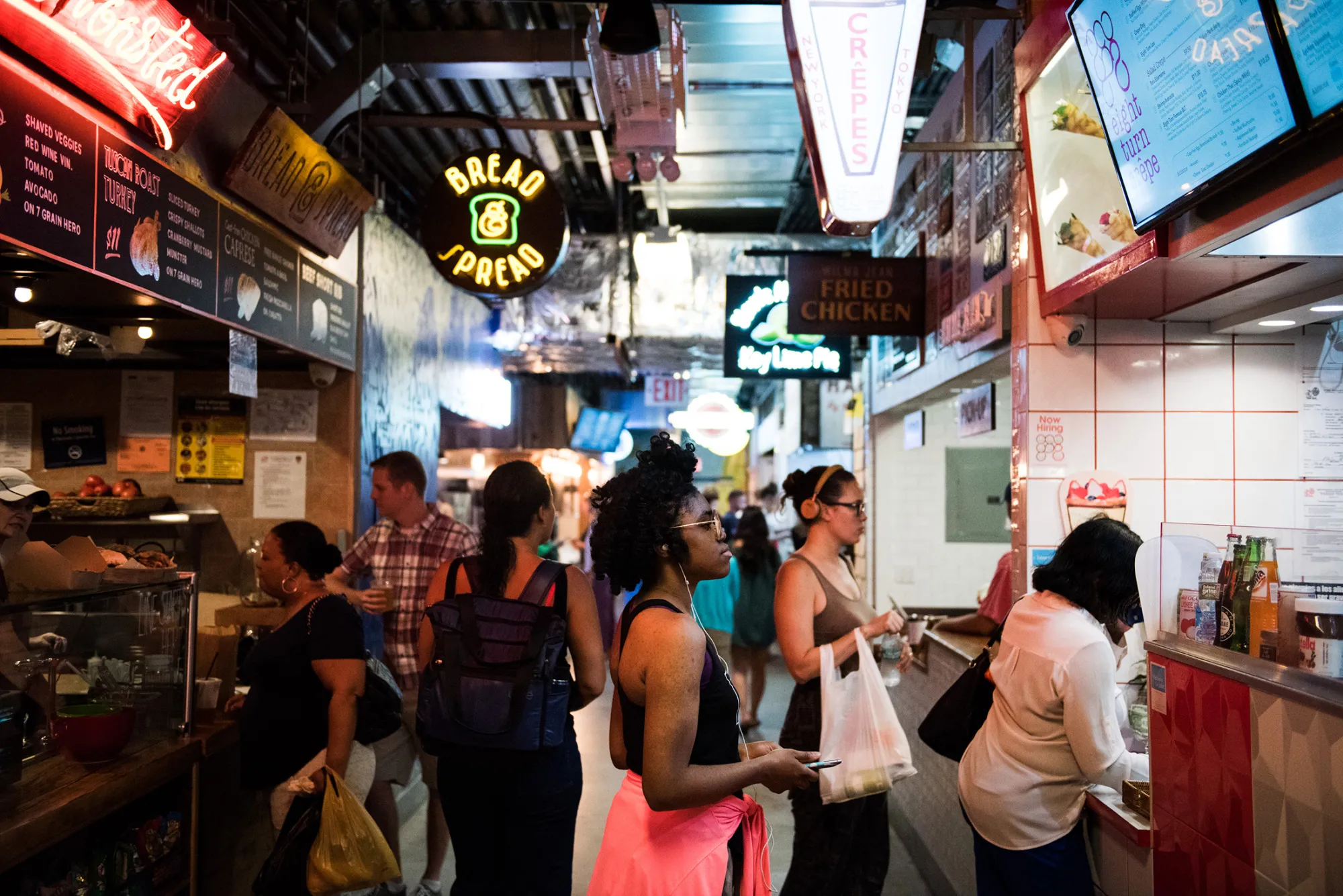 A woman views the menu of a food stand inside DeKalb Market Hall at City Point in the Brooklyn borough of New York, U.S., on Tuesday, July 18, 2017.
