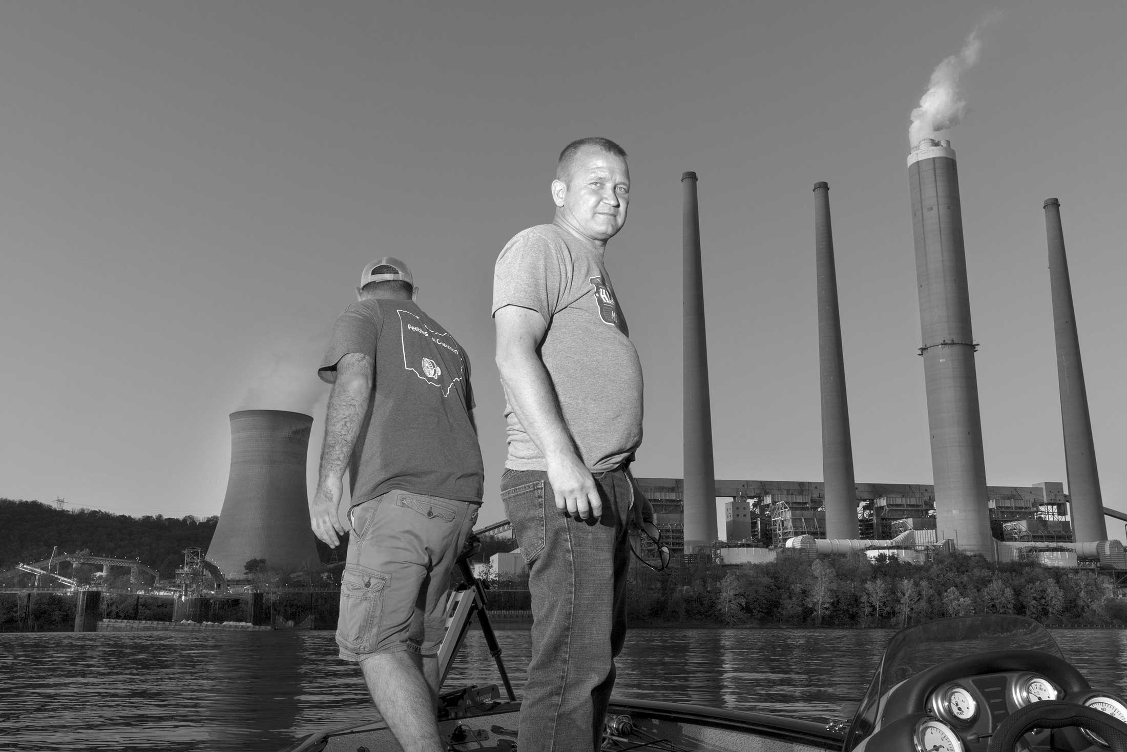 John Arnett fishes with a friend and former co-worker on the Ohio River. Behind them is Arnett’s workplace since 2004, J.M. Stuart Station, one of two&nbsp;coal-fired power plants in Adams County, Ohio. They’re scheduled to close in June.