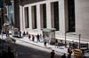 Pedestrians walk along Wall Street near the New York Stock Exchange.