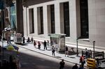 Pedestrians walk along Wall Street near the New York Stock Exchange.
