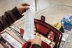 A customer looks at their sales receipt outside a supermarket in Paris.