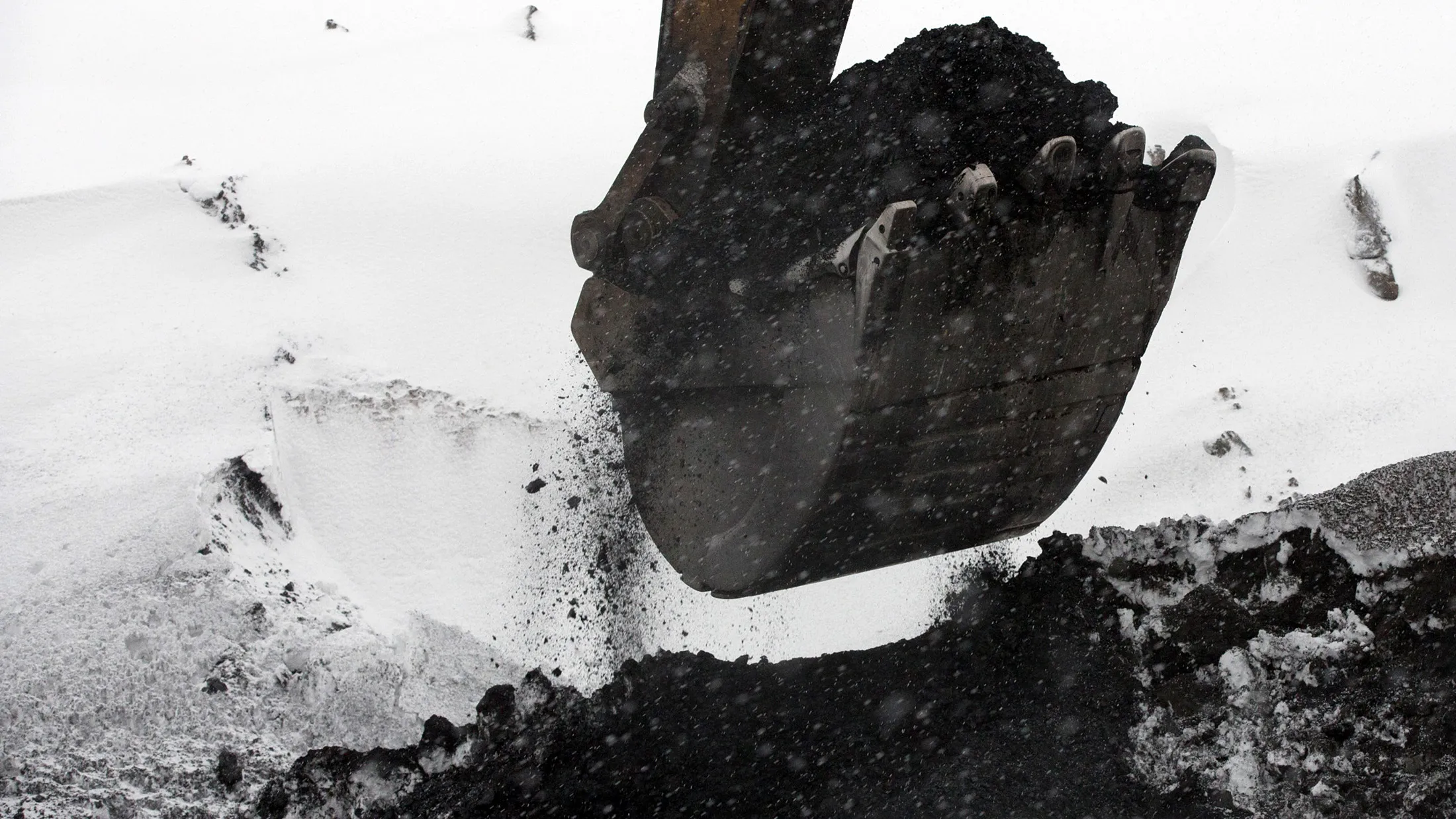 An excavator digs coal from a snow covered heap at a mine in Mezhdurechensk, Russia.
