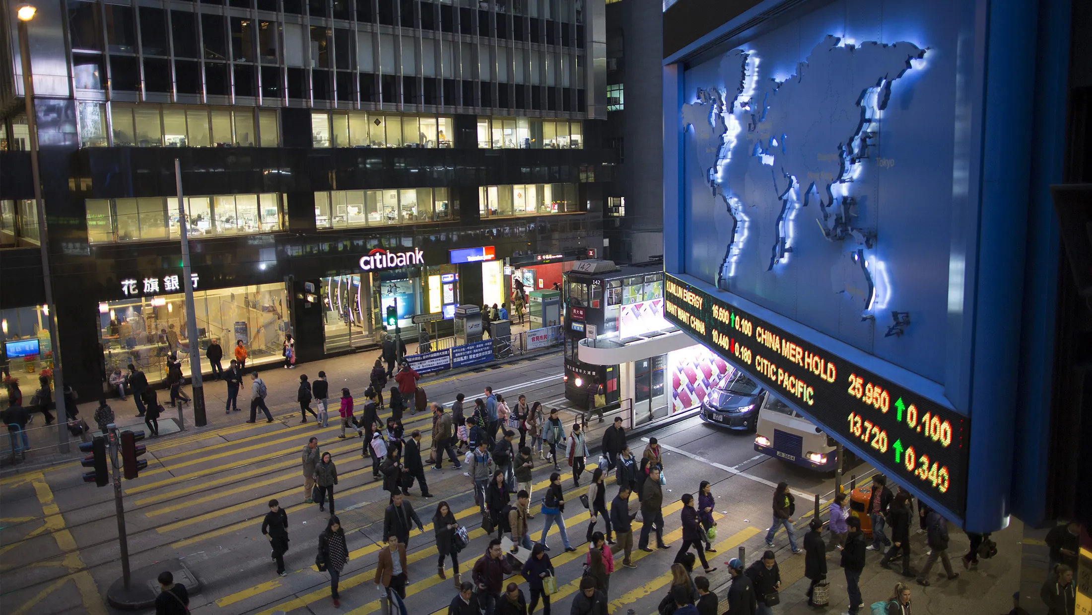 Pedestrians cross a road in the central business district of Hong Kong.
