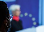 An attendee wears a protective face mask while watching Christine Lagarde, president of the European Central Bank (ECB), delivering a news conference in Frankfurt, Germany, on Thursday, Dec. 16, 2021. 