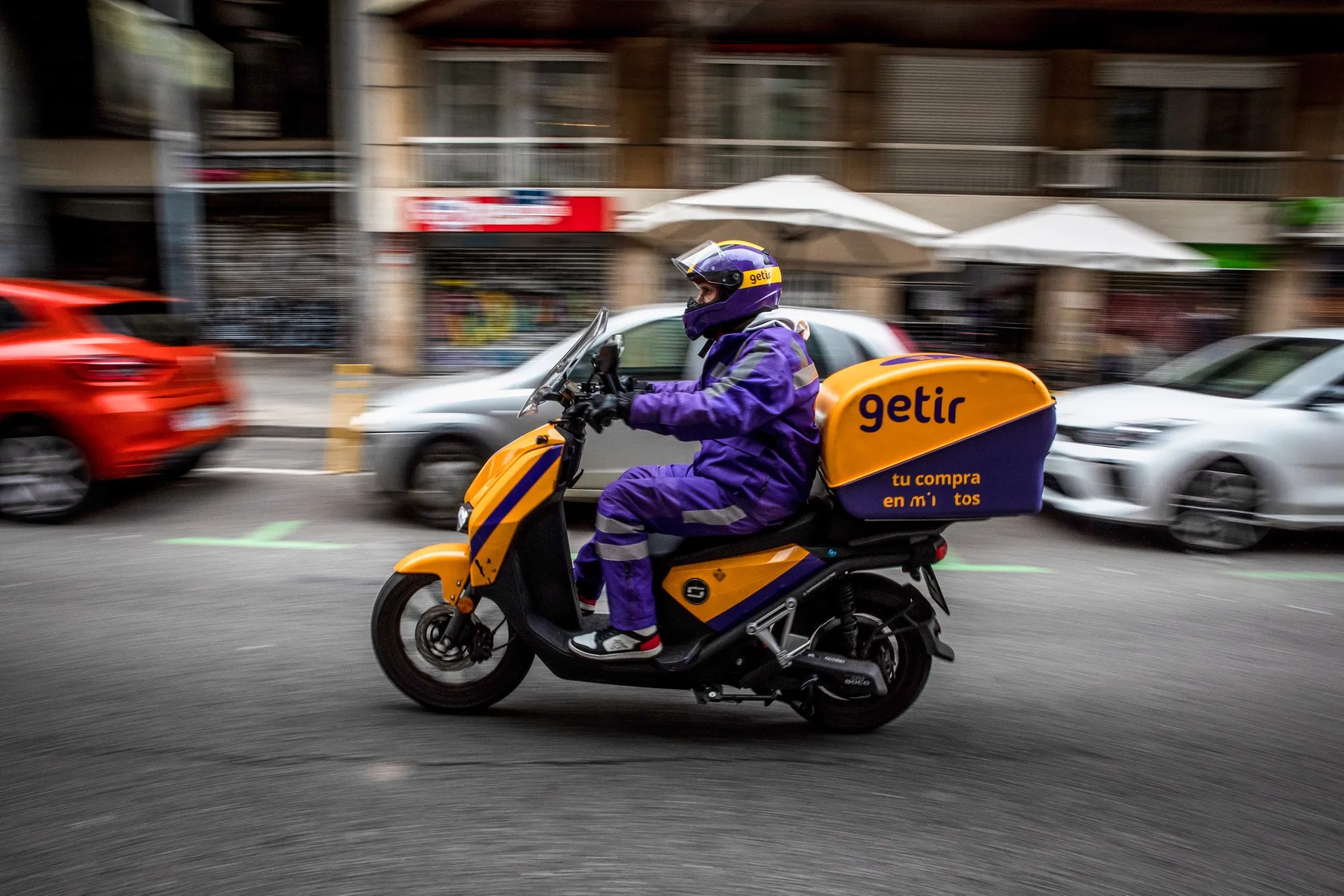 A courier for the food delivery service Getir rides along a street in Barcelona, Spain.