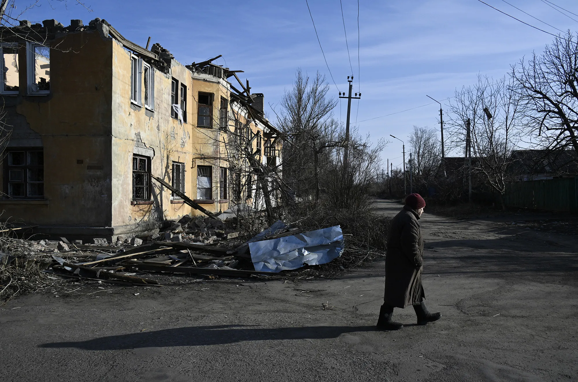 A local resident walks past a heavily damaged building in Kostyantynivka, Ukraine, on Feb. 14.