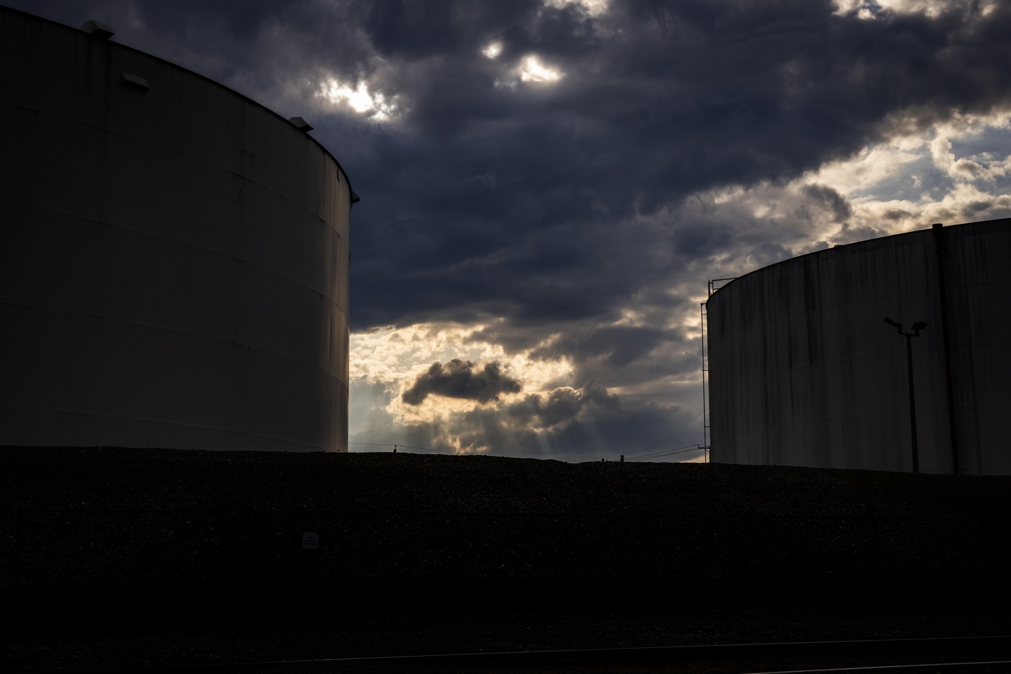 Fuel storage tanks beneath a dramatic sky. Photographer: Bloomberg Creative Photos/Bloomberg Creative Collection