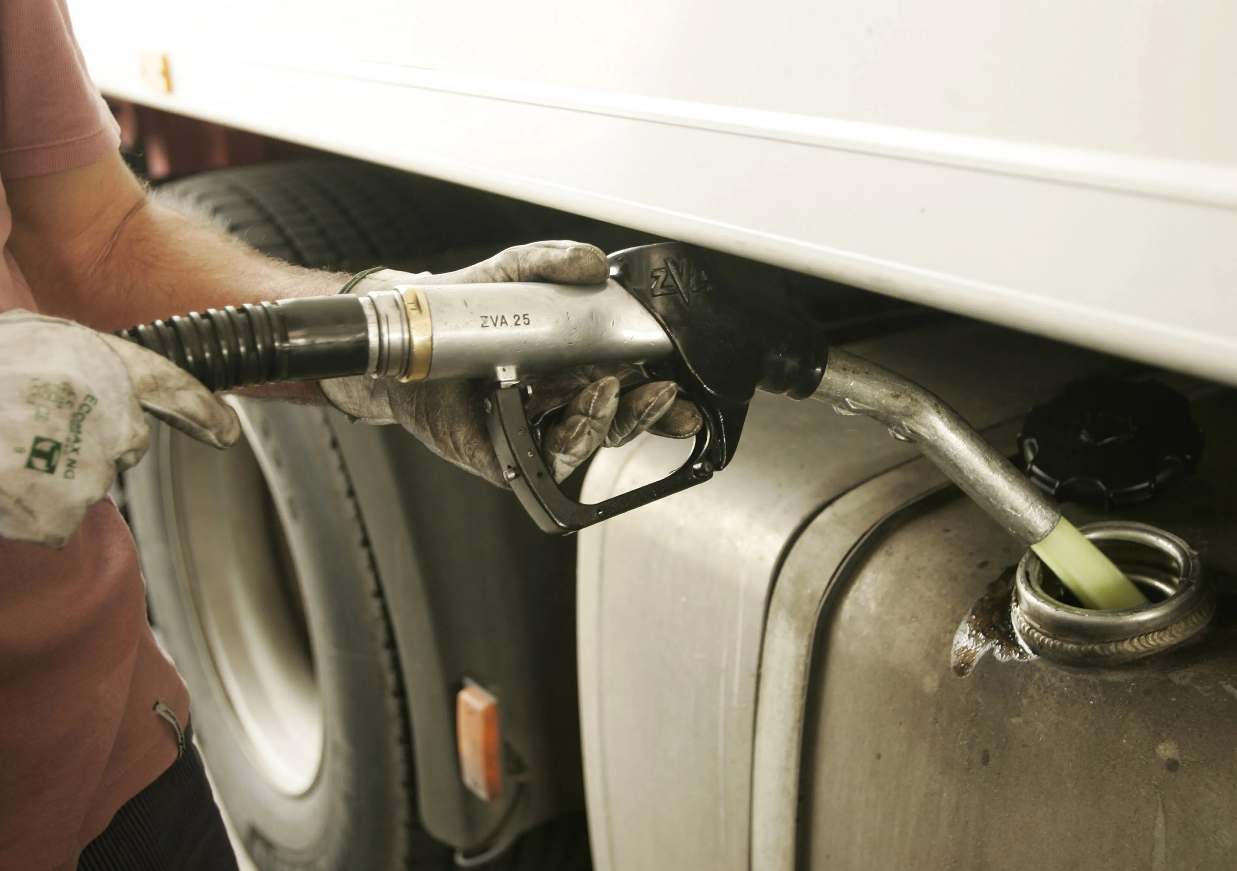A driver fills the tank of his truck with diesel.