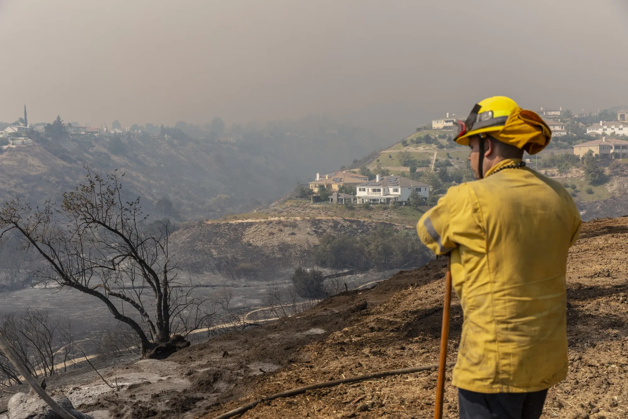A firefighter looks at damage during the Saddleridge fire in the Porter Ranch neighborhood of Los Angeles on Oct. 11.