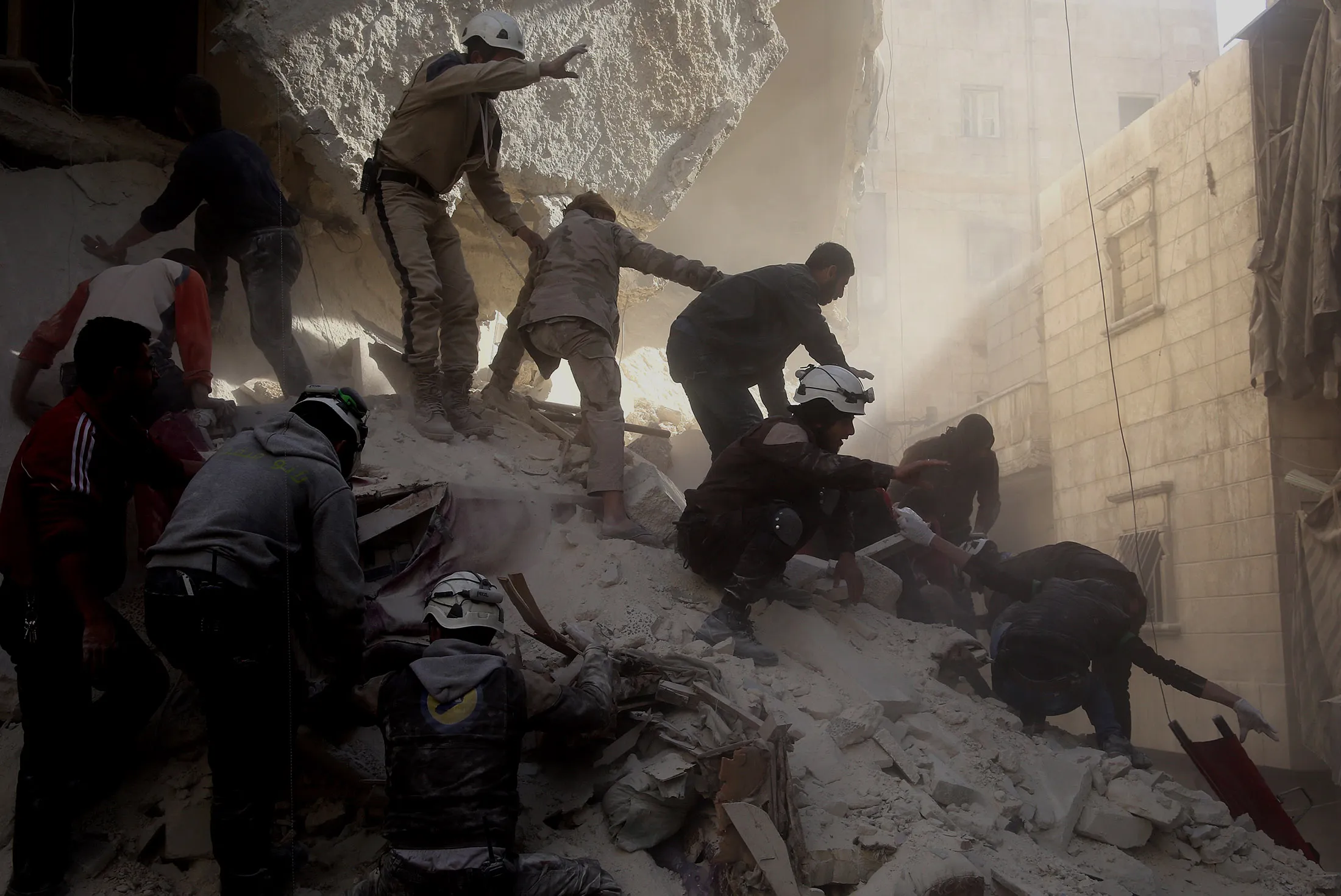 ALEPPO, SYRIA - MARCH 11: Civil defense team members try to rescue people from a wreckage of a building after war crafts belonging to the Russian army carried out airstrikes on opposition controlled al-Salihiya district in Aleppo as they break the cease fire in Syria on March 11, 2016.
