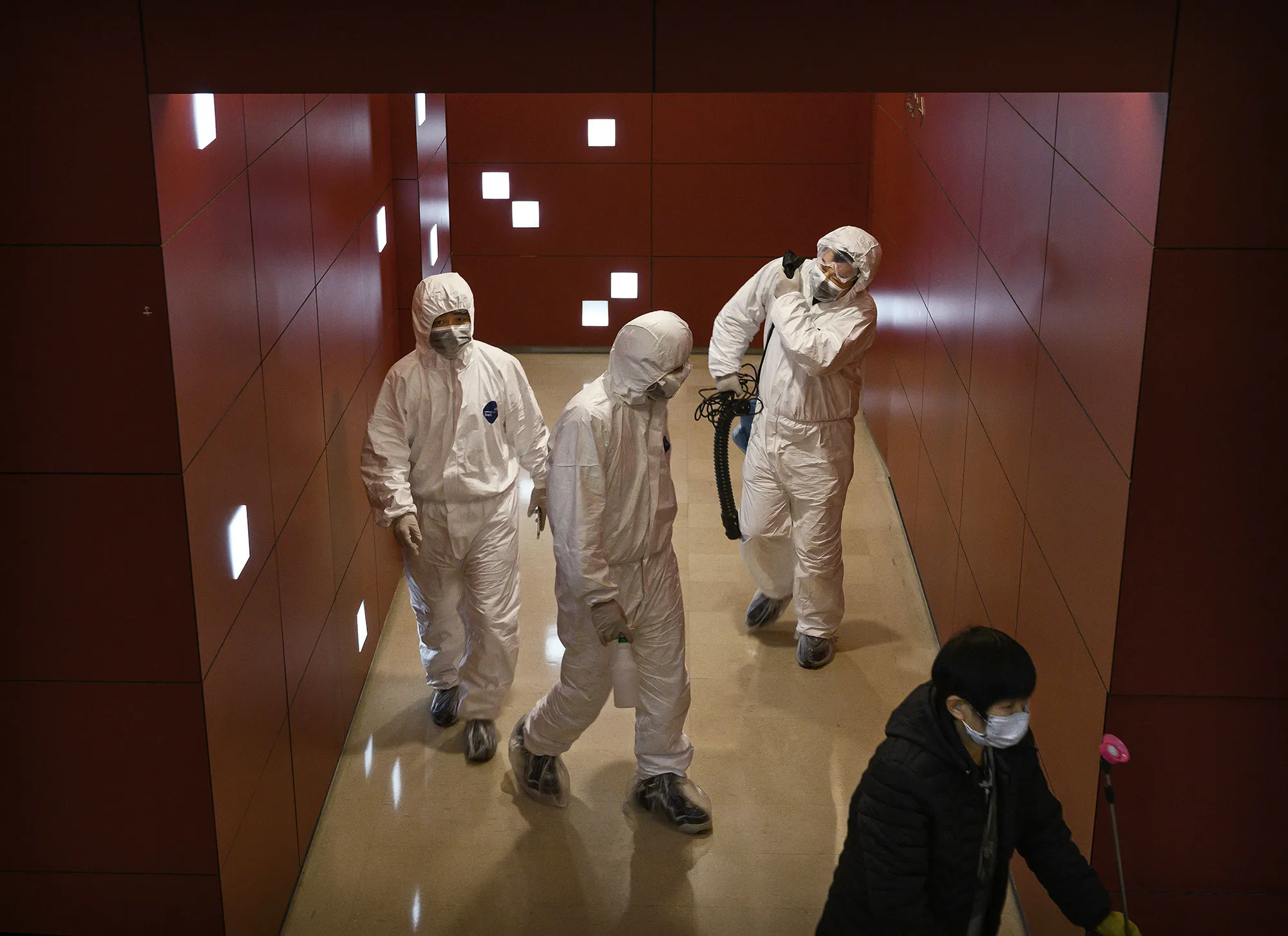 Workers wear protective suits inside a mall in Beijing.