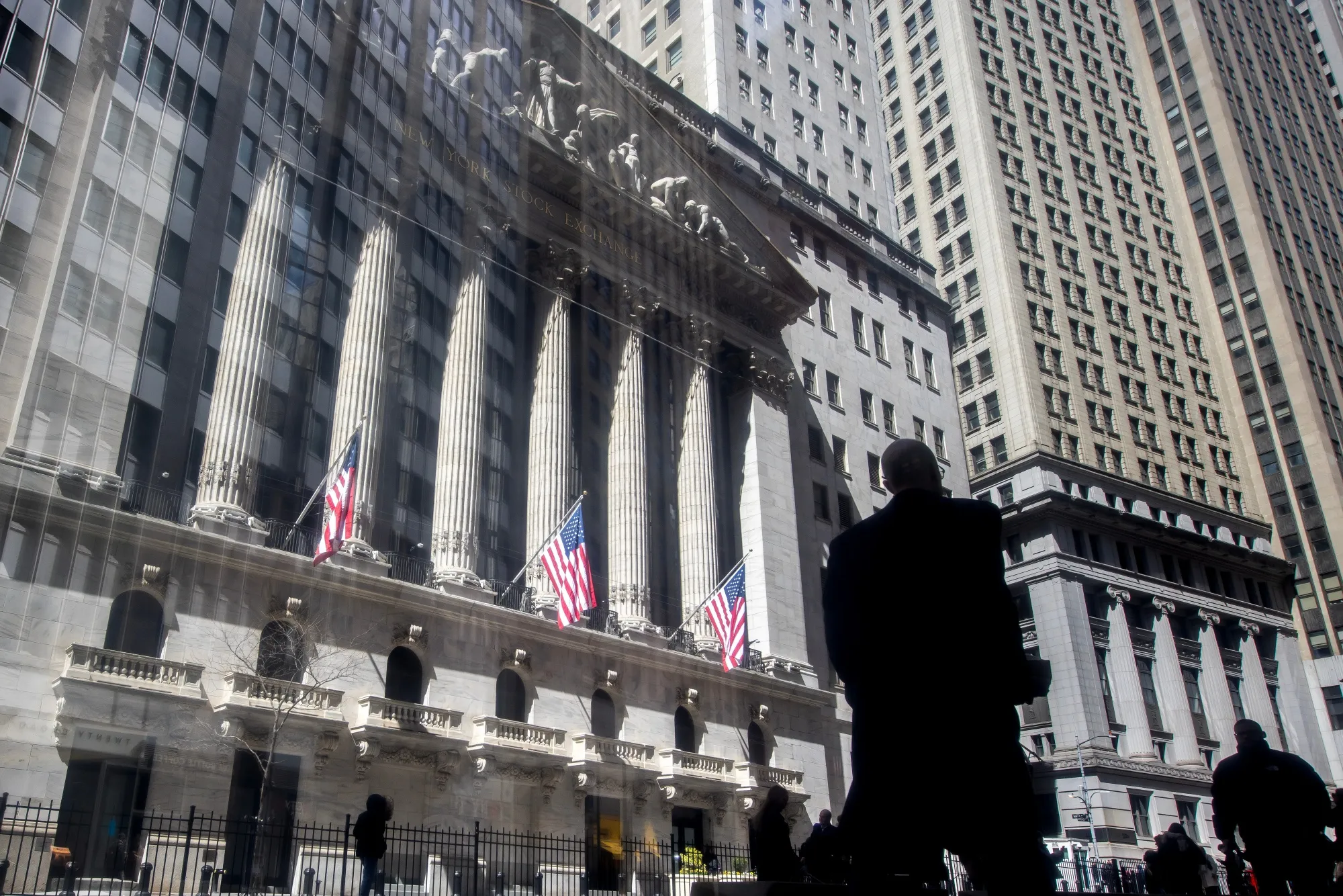 Pedestrians pass the New York Stock Exchange.