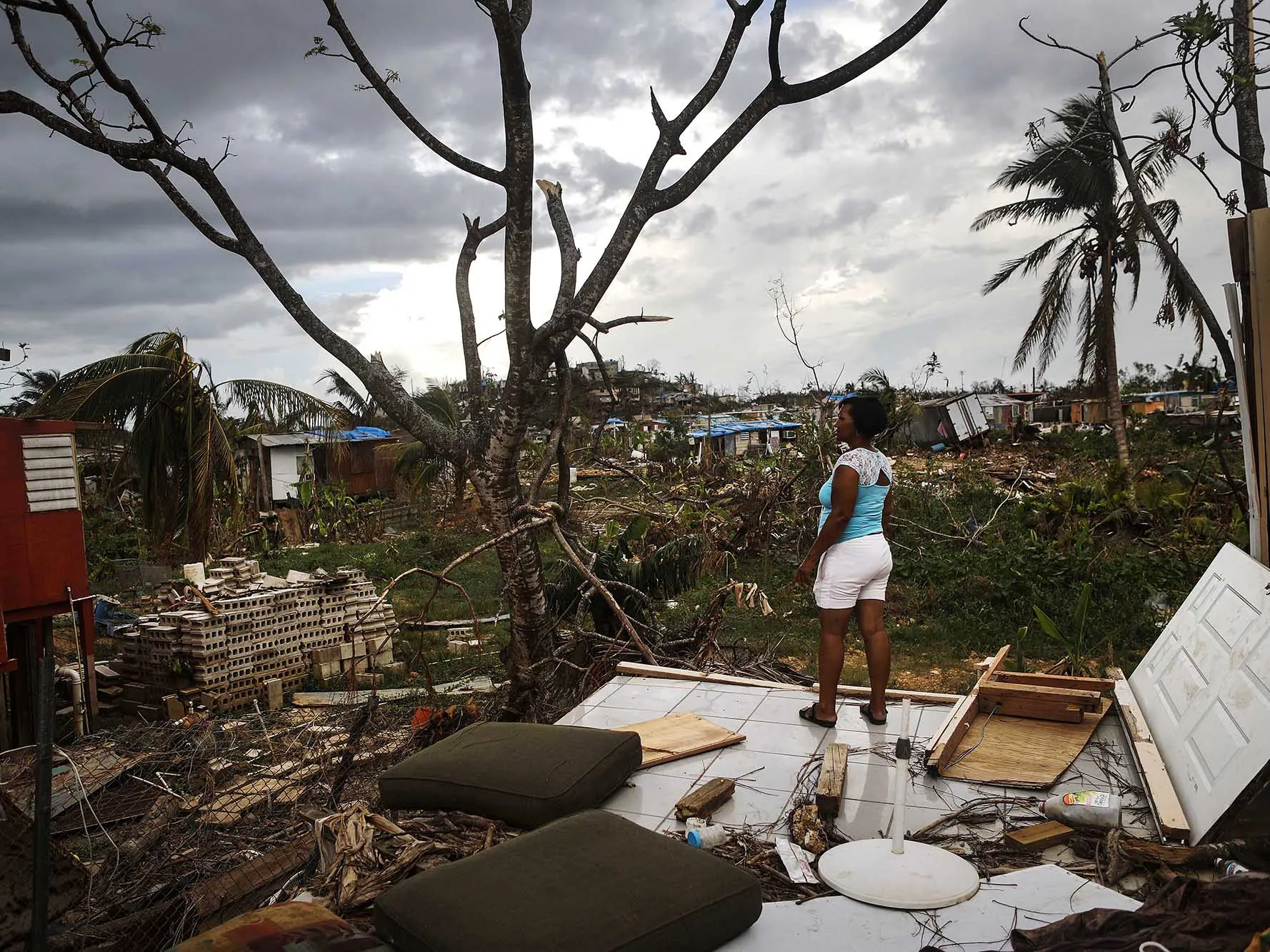 A woman stands on her property about two weeks after Hurricane Maria swept through the island on Oct. 5, 2017 in San Isidro, Puerto Rico.