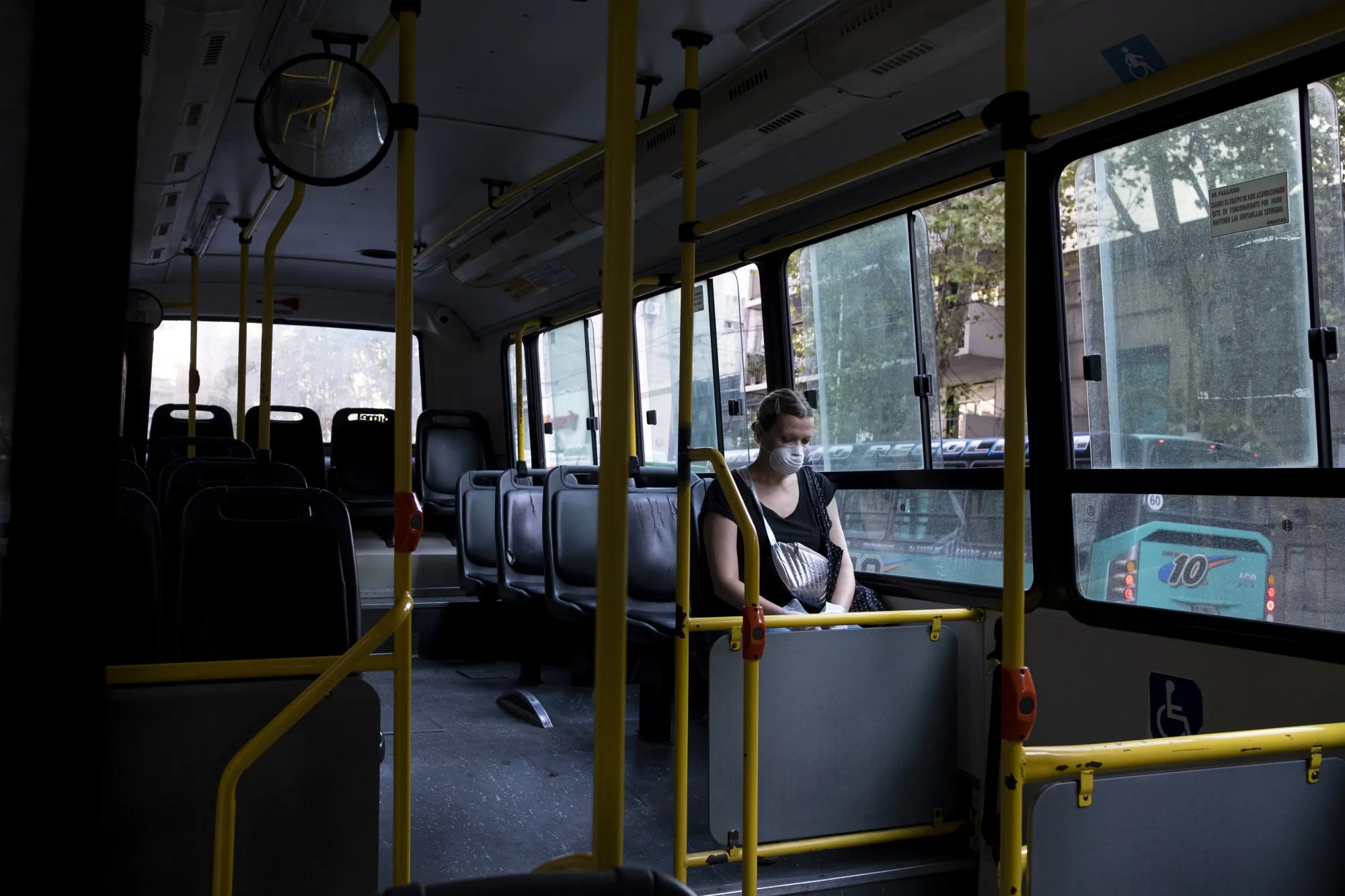 A commuter wearing a protective mask sits on an empty bus in Buenos Aires.