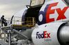 A FedEx Corp. cargo plane has load balancing weights removed as it is prepared on the tarmac at the company's distribution hub at Los Angeles International Airport (LAX) in Los Angeles, California, U.S., on Monday, Dec. 15, 2014. FedEx Corp. is scheduled to release earnings figures on Dec. 17.