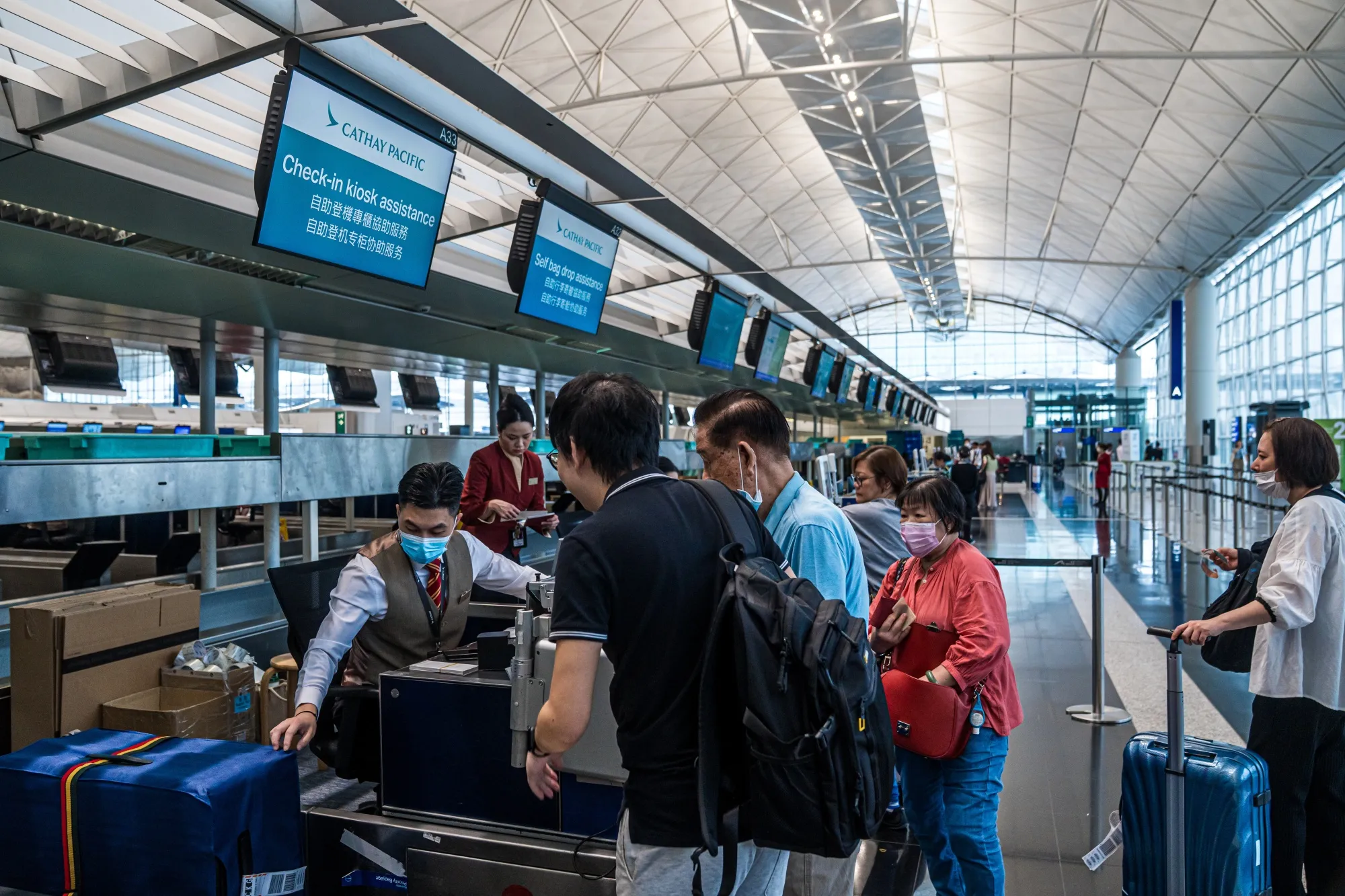 Travelers check into a Cathay Pacific flight.