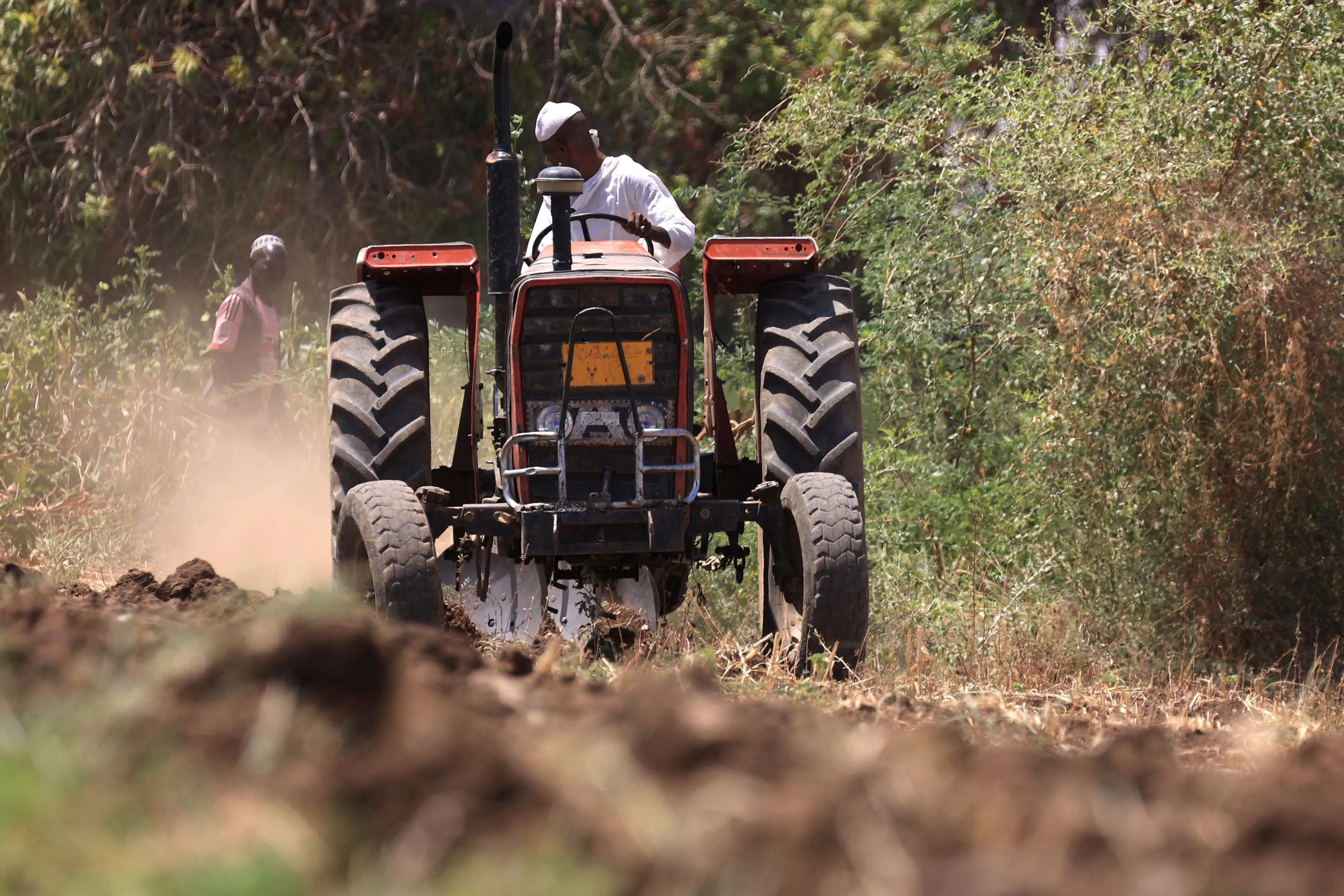 A farmer ploughs a field on his tractor in Shendi, Sudan.