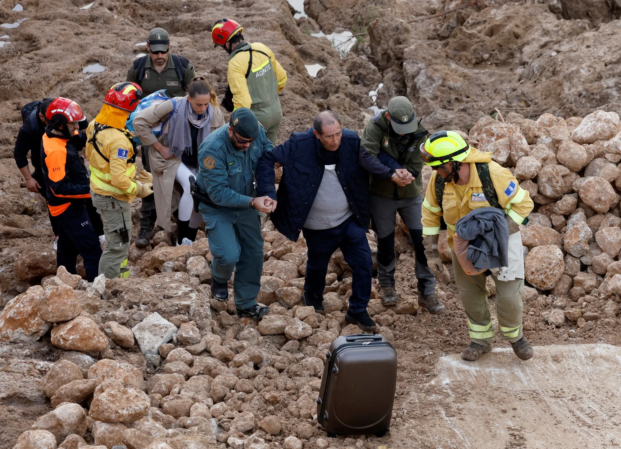 Emergency service workers help a resident in Letur, on Oct. 30.