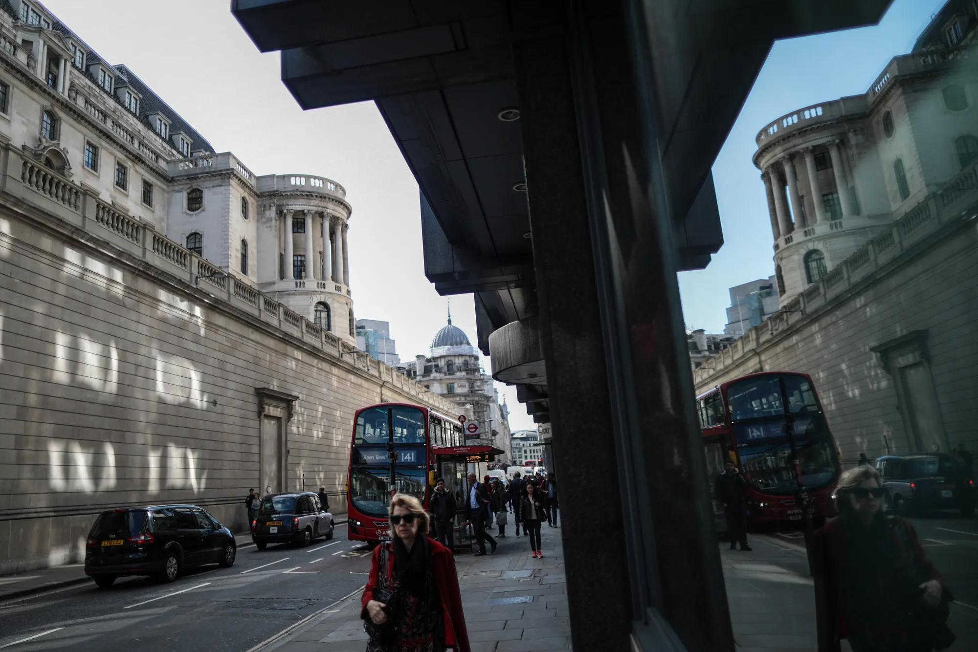 Pedestrians walk past the Bank of England in the City of London.

