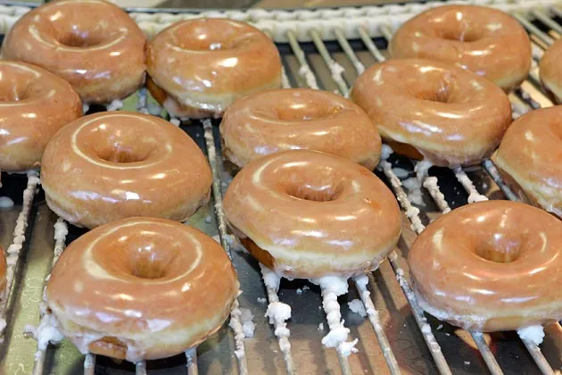 Glazed doughnuts roll along on a conveyor belt at a Krispy Kreme store in Charlotte, N.C.
