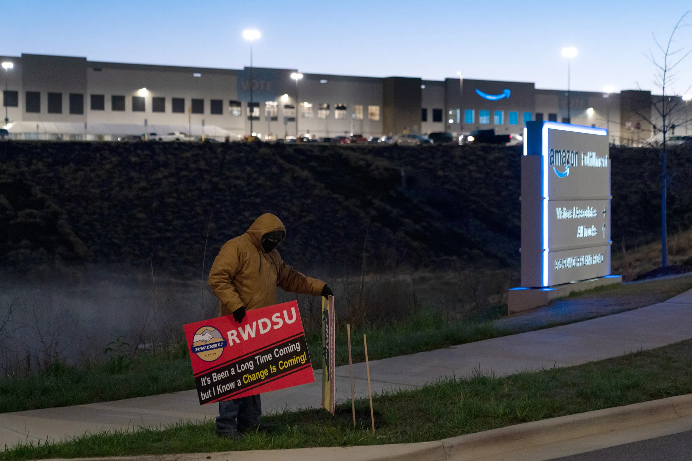 A demonstrator holds a sign outside the Amazon fulfillment warehouse in Bessemer, Ala., on March 29.