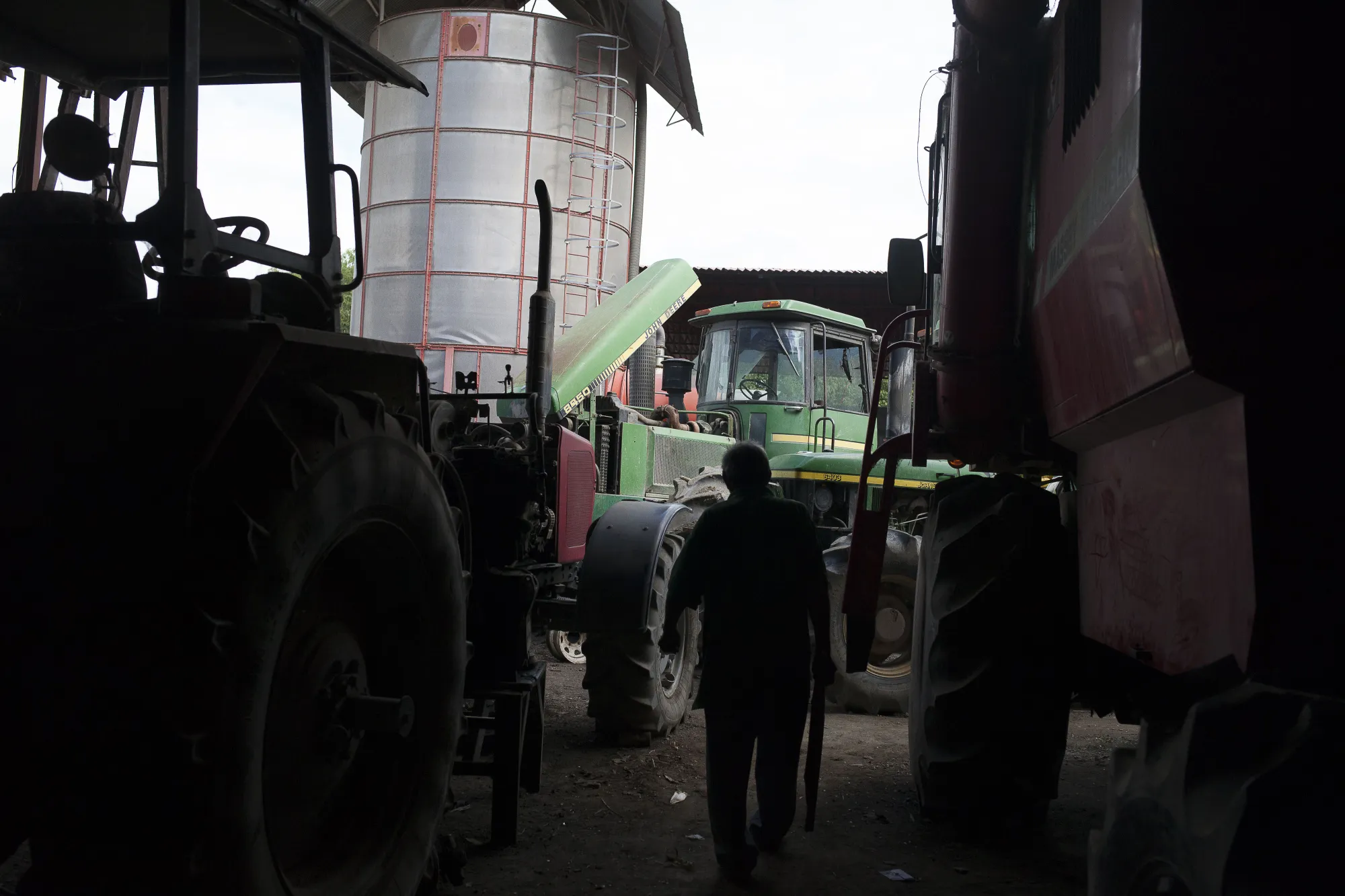 A farmer passes through a graveyard of idled machinery at a farm in Turen, Venezuela, in 2017.