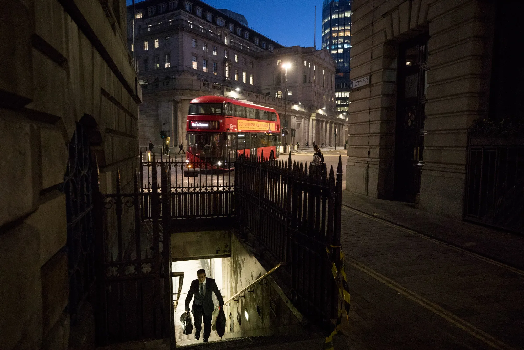 A commuter exits an entrance to Bank Underground station in view of the Bank of England in the City of London.