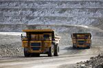 Dump trucks carrying raw ore at the open pit copper mine.
