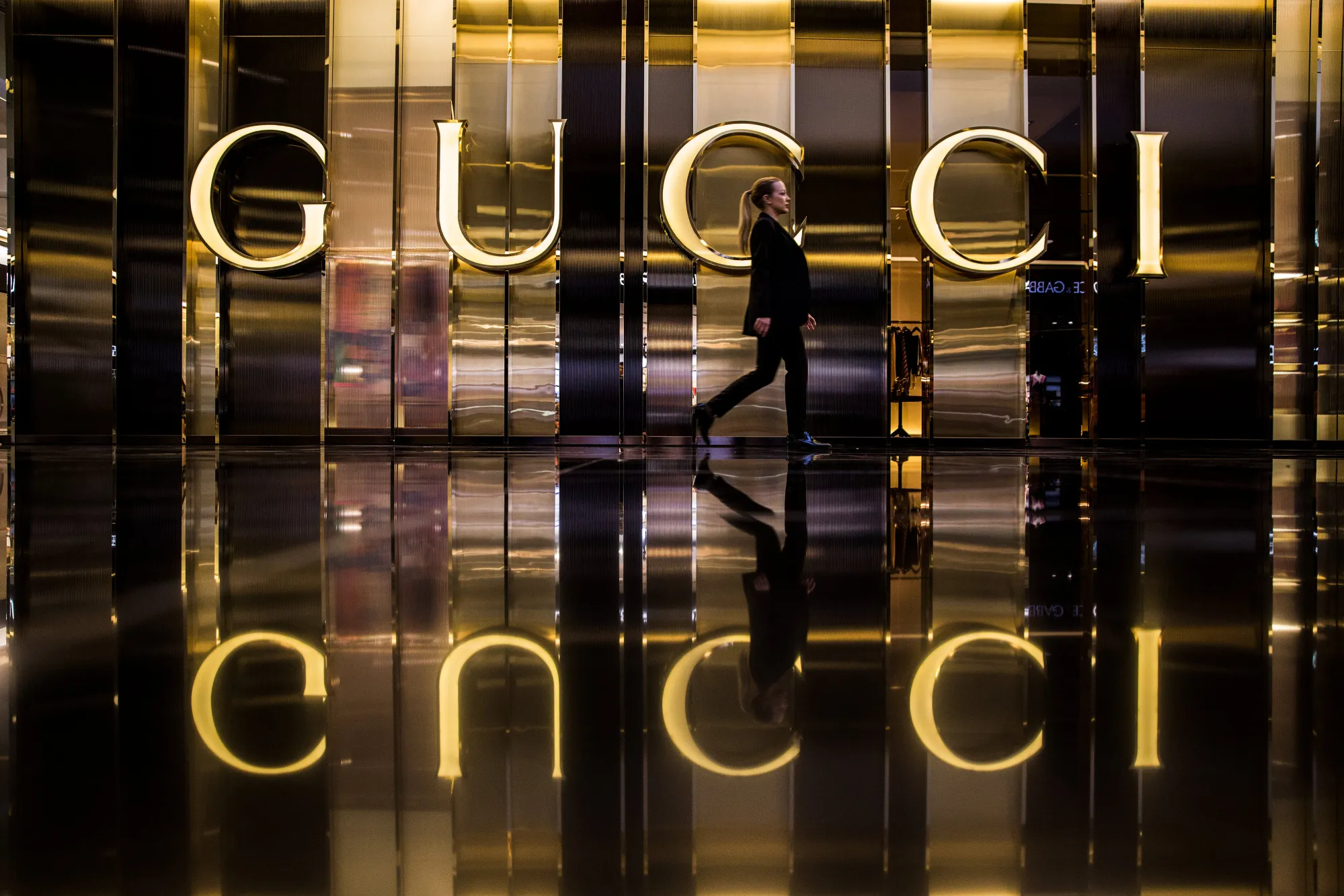 A person walks past a Gucci store.