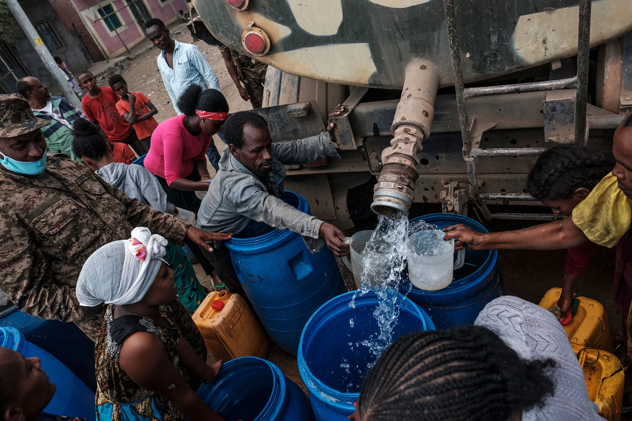 People collect water distributed by the Ethiopian Defense Forces in Hadaelga, the Tigray region of Ethiopia.