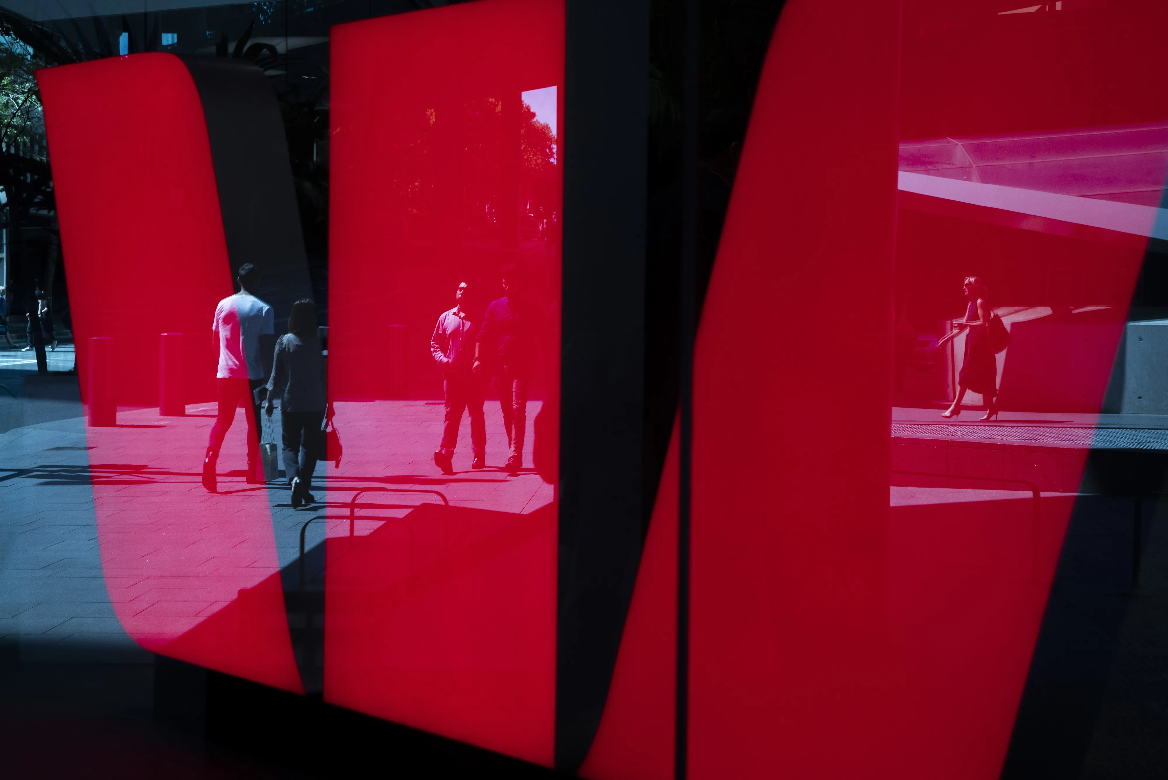 Pedestrians are reflected in a Westpac Banking Corp. logo in Sydney, Australia.