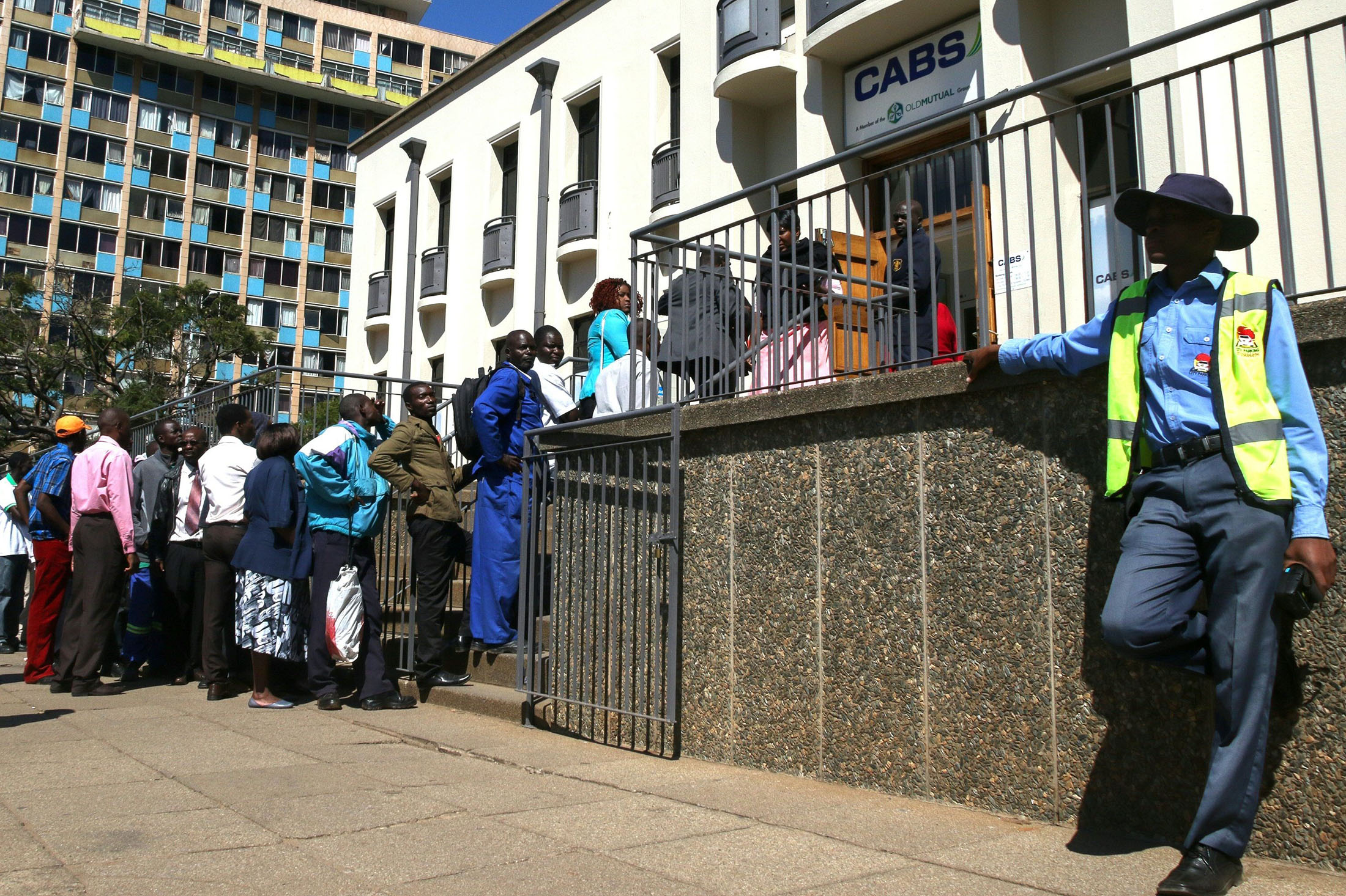 Zimbabweans queue to withdraw cash outside a bank on May 5, 2016 in Harare, Zimbabwe. Zimbabweans formed long queues outside banks on May 5 after the government slapped new limits on cash withdrawals and announced that 'bond notes' at par with the US dollar would be introduced. / AFP / JEKESAI NJIKIZANA (Photo credit should read JEKESAI NJIKIZANA/AFP/Getty Images)
