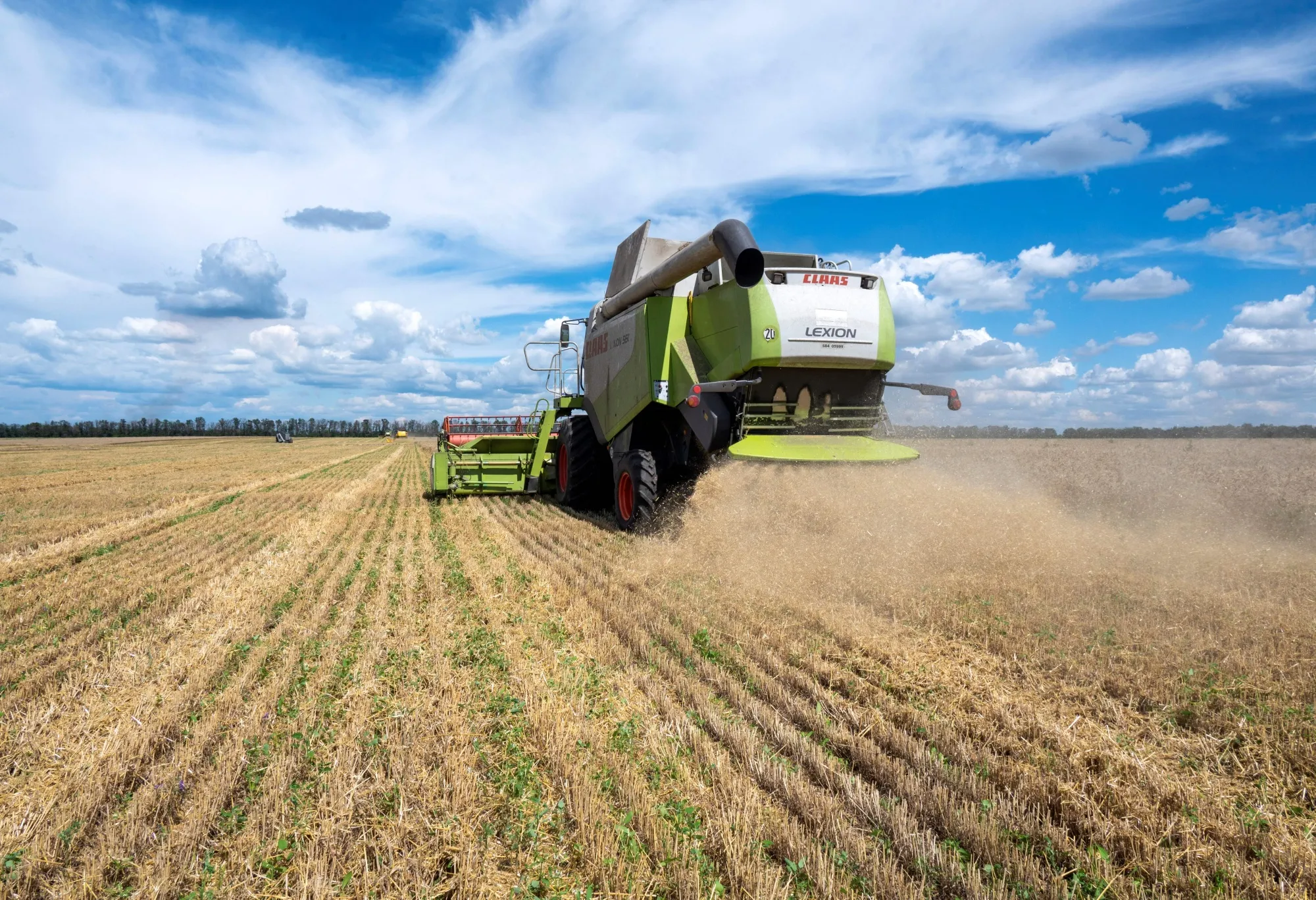 Farmers harvest a wheat field in the Ukrainian Kharkiv region.