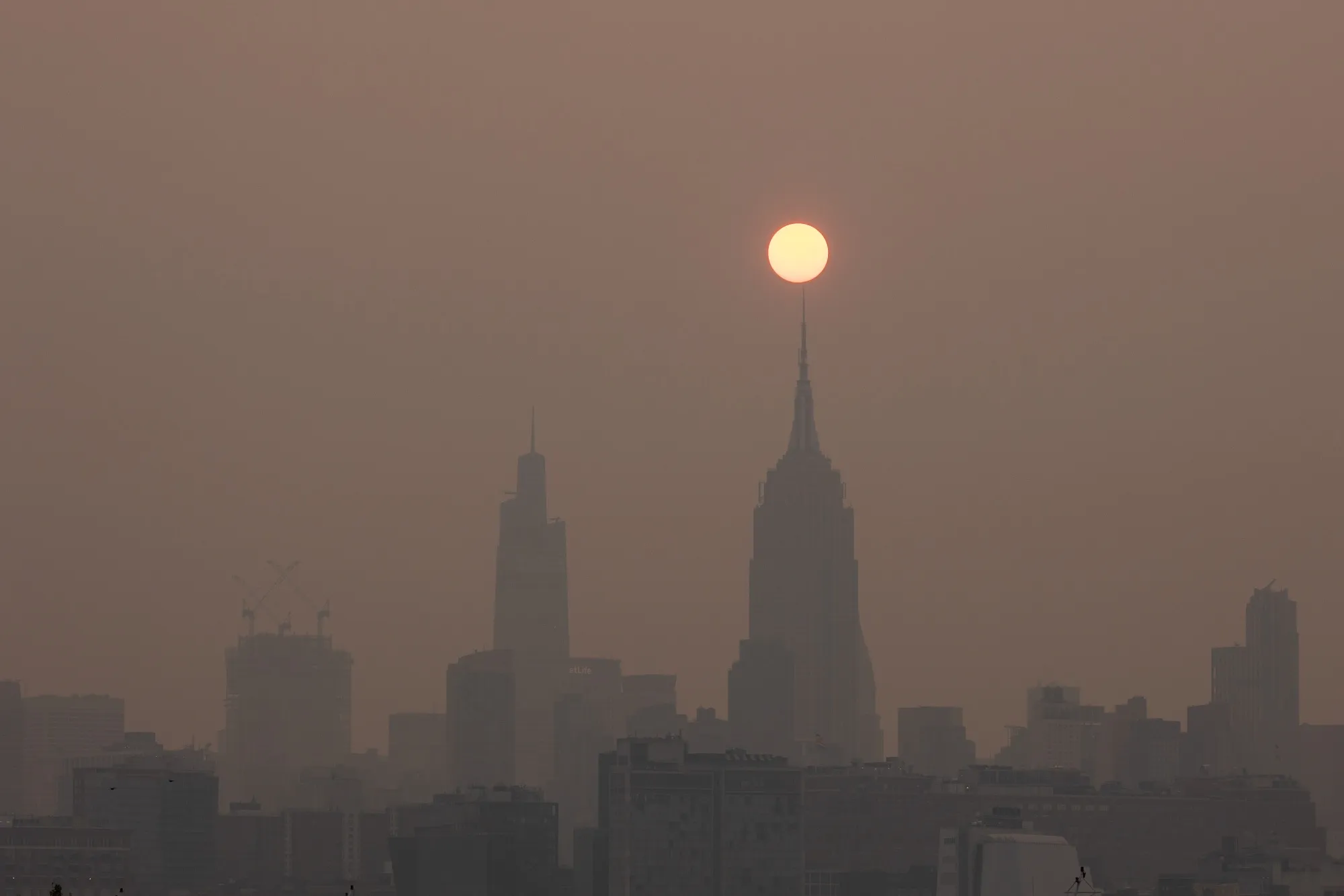 Buildings in the Manhattan skyline shrouded in smoke from Canada wildfires at sunrise in Jersey City, New Jersey, US, on Wednesday, June 7, 2023. New York was the most polluted major city in the world on Tuesday night, as smoke from Canadian wildfires blanketed the city in haze, according to the IQAir website.