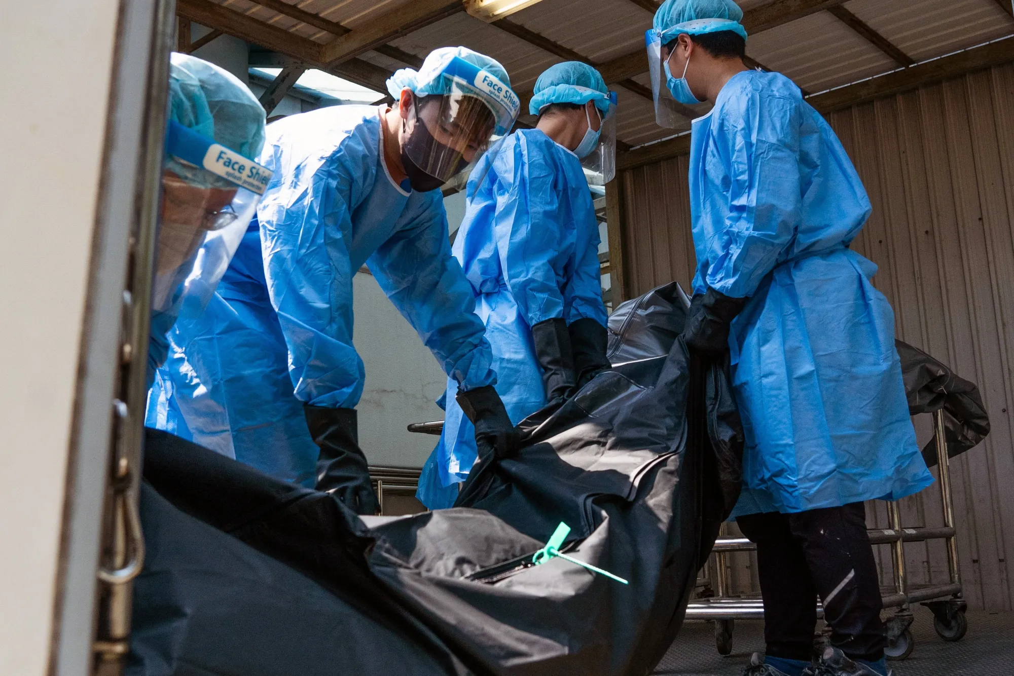 Workers at a mortuary move the body of a deceased person in Hong Kong, on March 4.